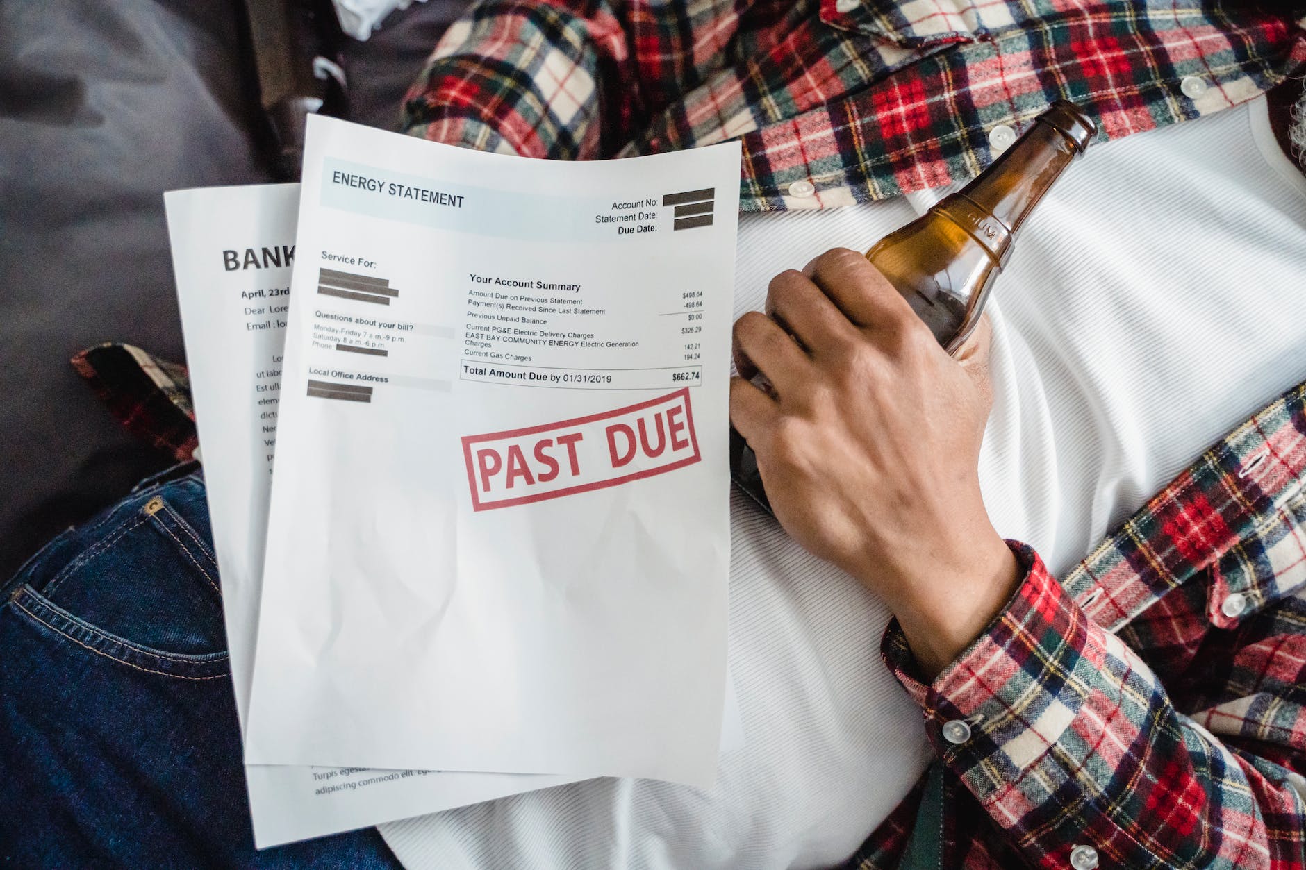 unpaid bills and man lying down with a bear bottle